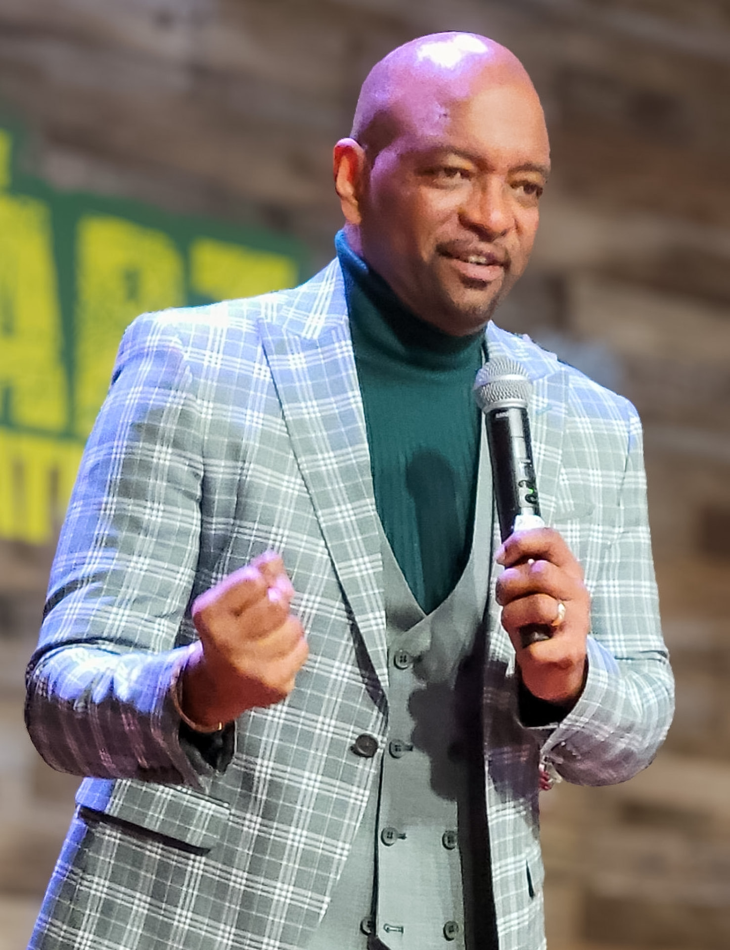 A man preaches to the congregation with a microphone in hand