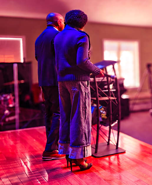 Two church leaders stand on stage together during a service